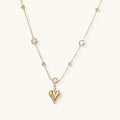 Crystal Heart Charm Necklace in gold with crystals on a plain background