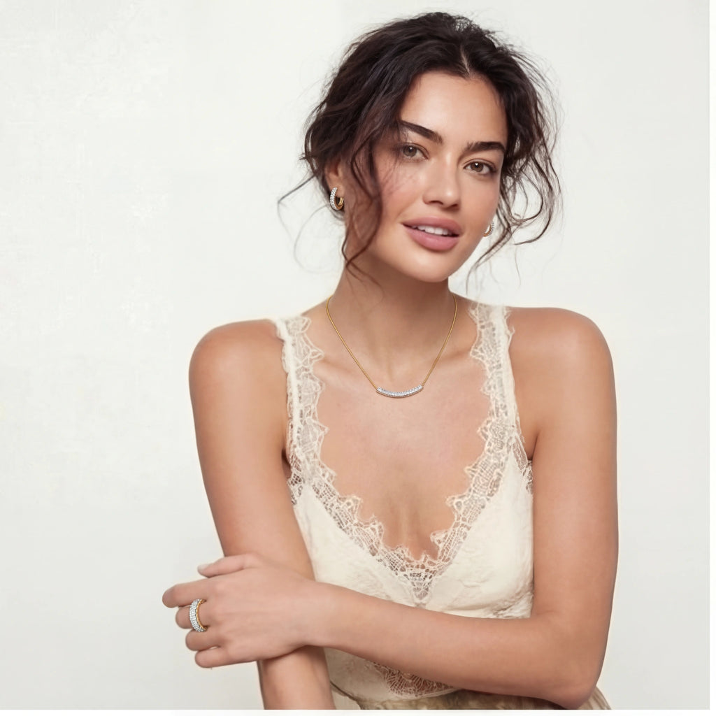 Woman wearing Crescent Glow Set gold necklace, earrings, and ring